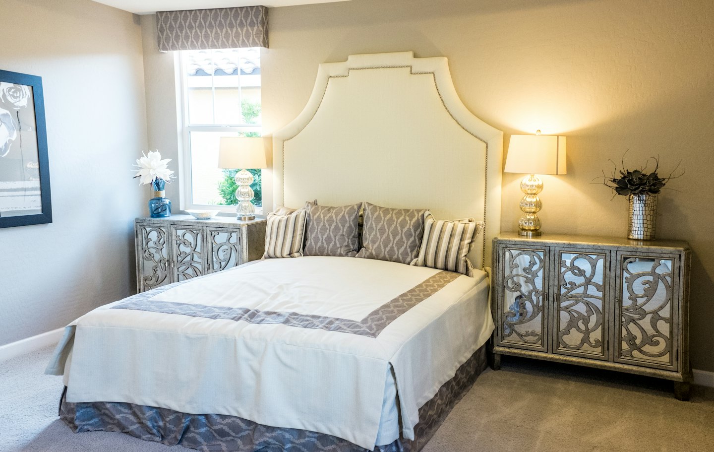 Luxuriöses Schlafzimmer mit Polsterkopfteil und spiegelnden Nachttischen.